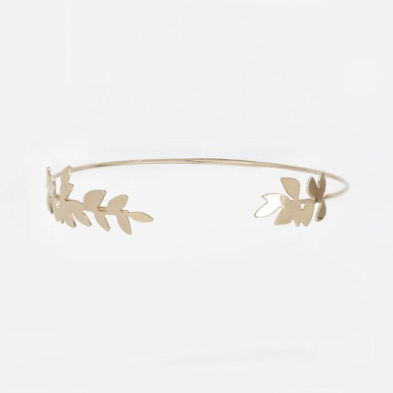 Un jonc de créateur doré, avec un motif feuilles de frêne.