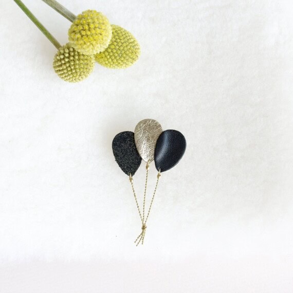 broche de createur en forme de ballons noirs et dorés