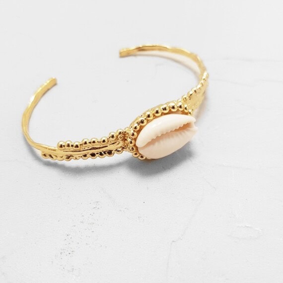 Bracelet Jonc Oia, avec un coquillage cauri, en plaqué or. Chez Poisson Plume.