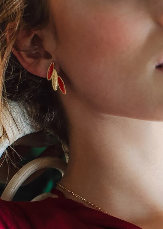 boucles plumes ara rouge profond portées. Chez Poisson Plume bijoux.