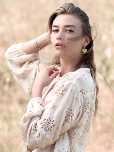 boucles d'oreilles cœur Linda - créoles dorées portées par une femme