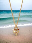 Collier amulette cuivrée abeille devant une plage - Bijou Gri-gri