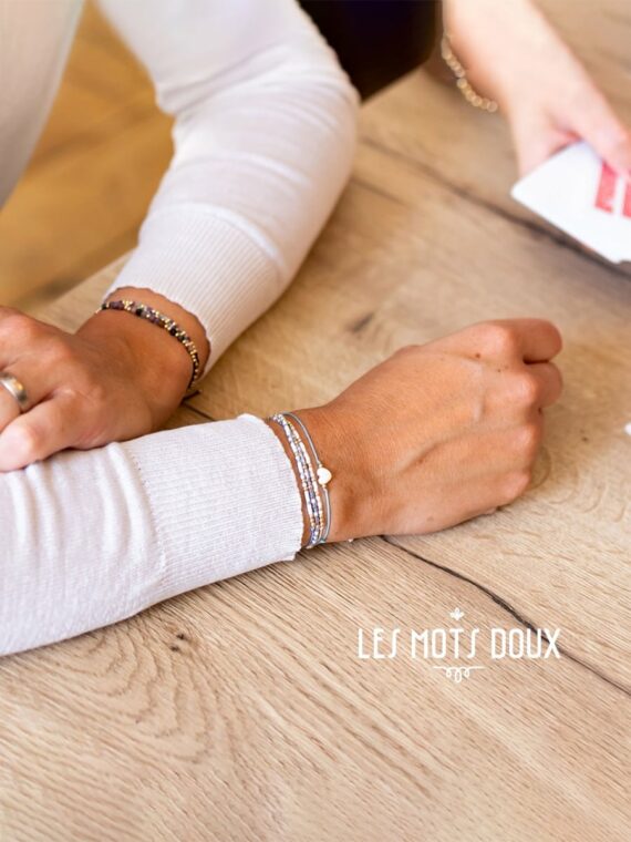 Bracelet code morse avec le message Magie et autres bracelets portés par une femme.