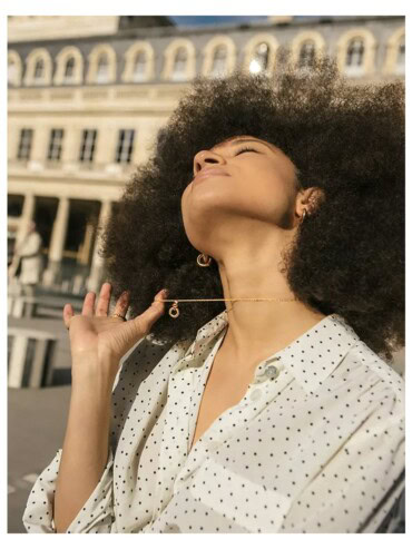 Femme portant les petites créoles dorées Charlotte.