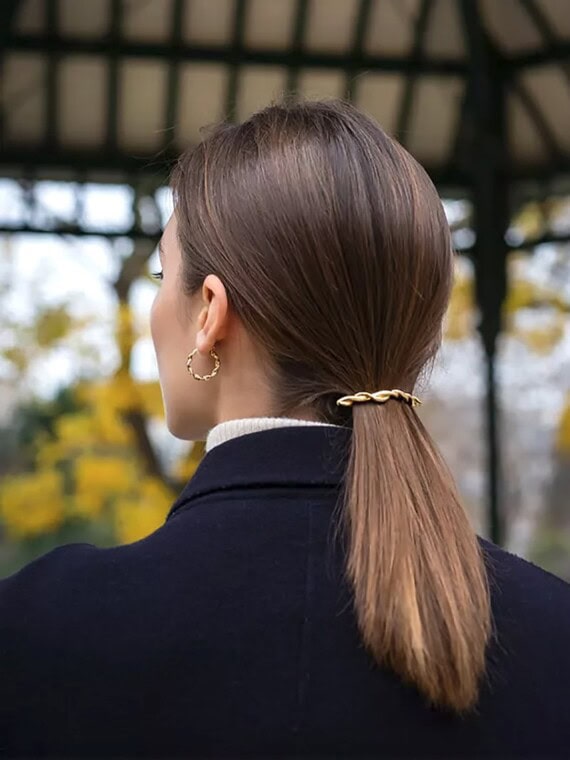 Petites créoles torsadées dorées Esméralda portées par une femme.