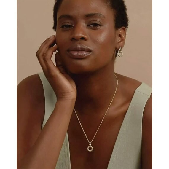 Collier et boucles d'oreilles louise damas portés par une femme