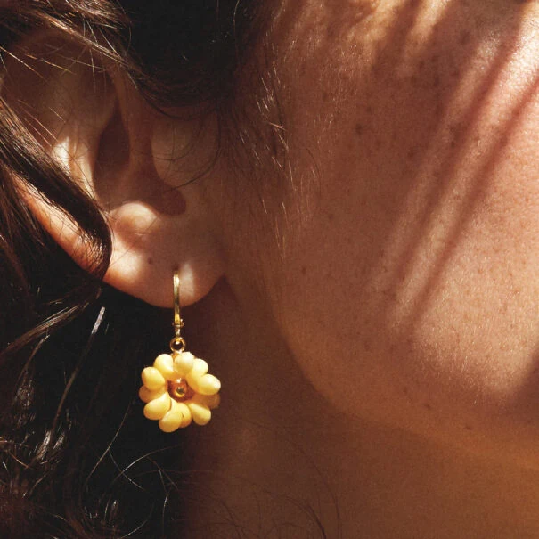 Petite boucle d'oreille Raphaël fleur coquillage à l'unité portée par une femme