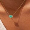 Collier Sangha Turquoise. ras-de-cou doré à l'or fin, porté par une femme. Pendentif rectangulaire.