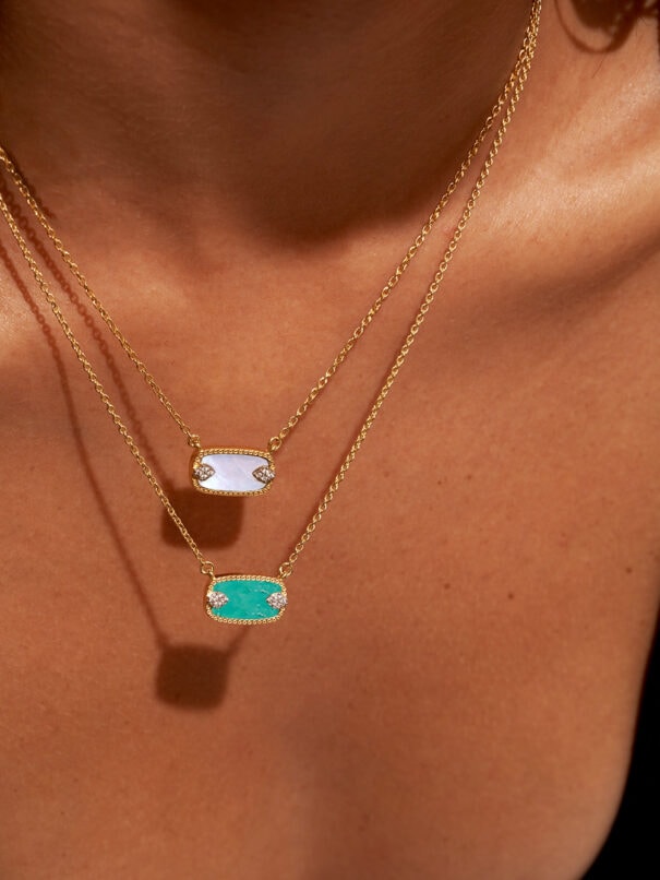 Collier Sangha nacre et collier de la même collection turquoise. Ras-de-cou doré à l'or fin, porté par une femme. Pendentif rectangulaire.