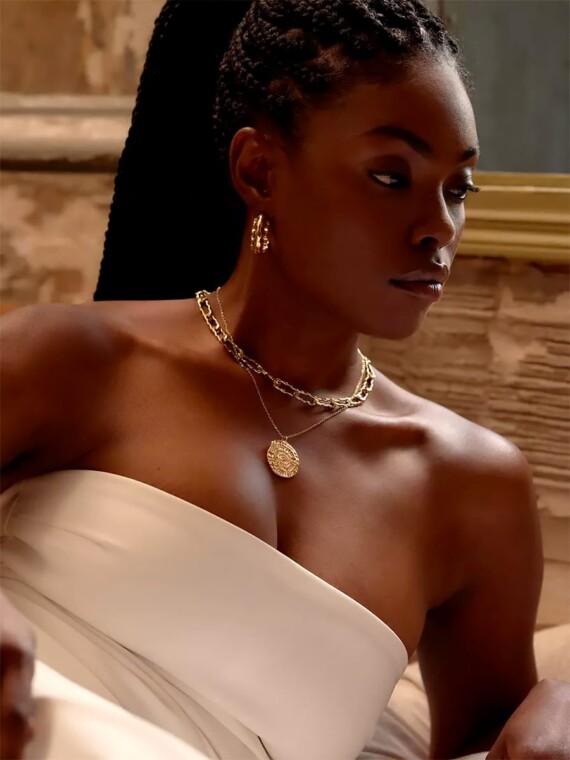 Collier médaille Vénus. Femme en robe de soirée.