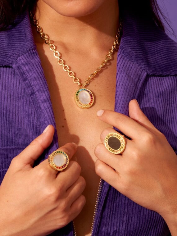 Une femme porte le Collier de la collection Hera de Be maad. Pierre nacre naturelle et pierres zircons. Elle porte aussi les bagues HERA de la même collection