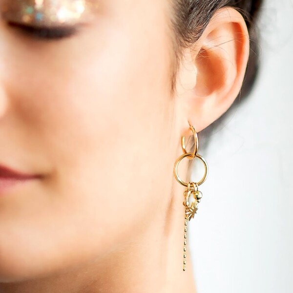 mono Boucle d'oreille DREAM. Zoom sur la Boucle d'oreille pendante à l'unité, portée par une femme. Un bijou doré à l'or fin.