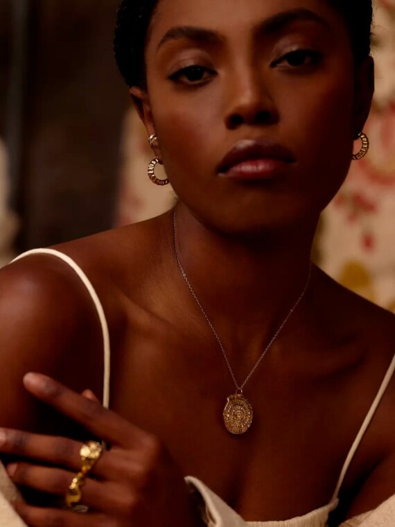 Petites créoles vénus portées par une femme. Bijoux dorés à l'or fin.
