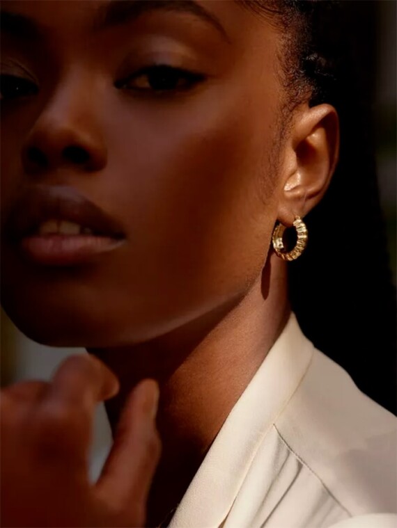 Petites créoles vénus portées par une femme. Bijoux dorés à l'or fin.