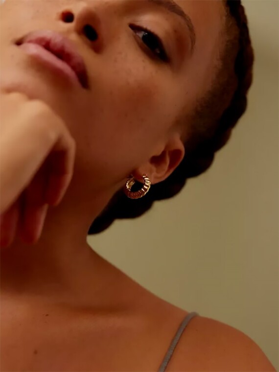 Petites créoles vénus portées par une femme. Bijoux dorés à l'or fin.