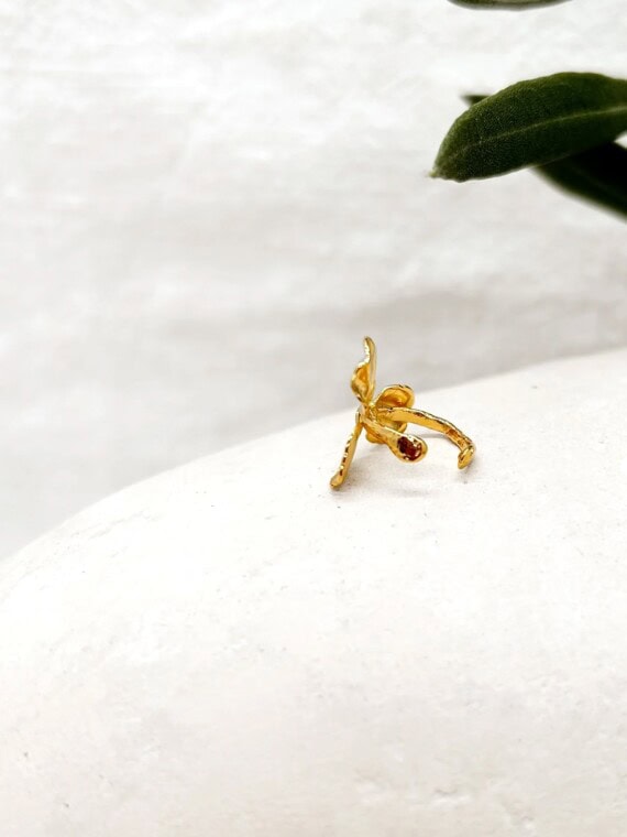 Earcuff Flora. Bague d'oreille en forme de fleur, portée par une femme. Bijou doré fait-main à paris.