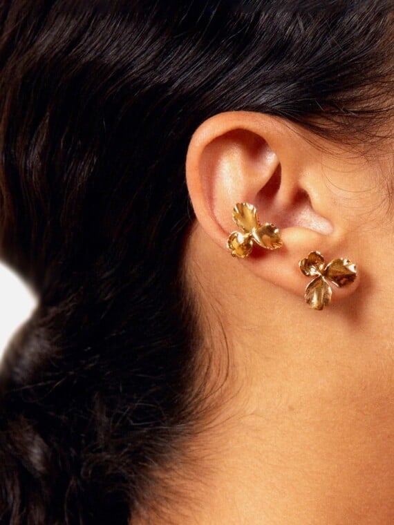 Earcuff Flora. Bague d'oreille en forme de fleur, portée par une femme. Bijou doré fait-main à paris.