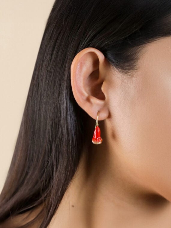 Femme avec les boucles d'oreilles fleur clochette grenade betty
