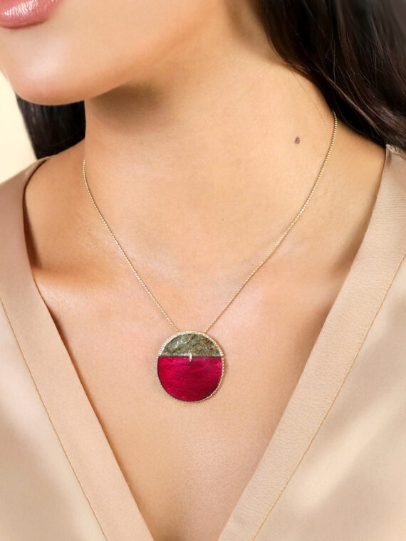 Femme portant le Collier disque soleil Marly de Franck Herval, en capiz bordeaux effet velours, laiton doré à l’or fin et cristal Swarovski.