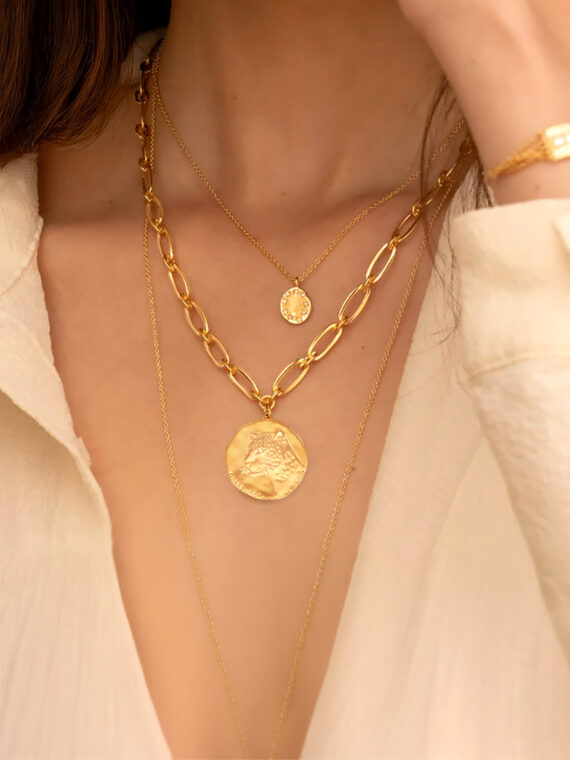 Collier médaille panthère porté par une femme. Bijou de créateur doré à l'or fin