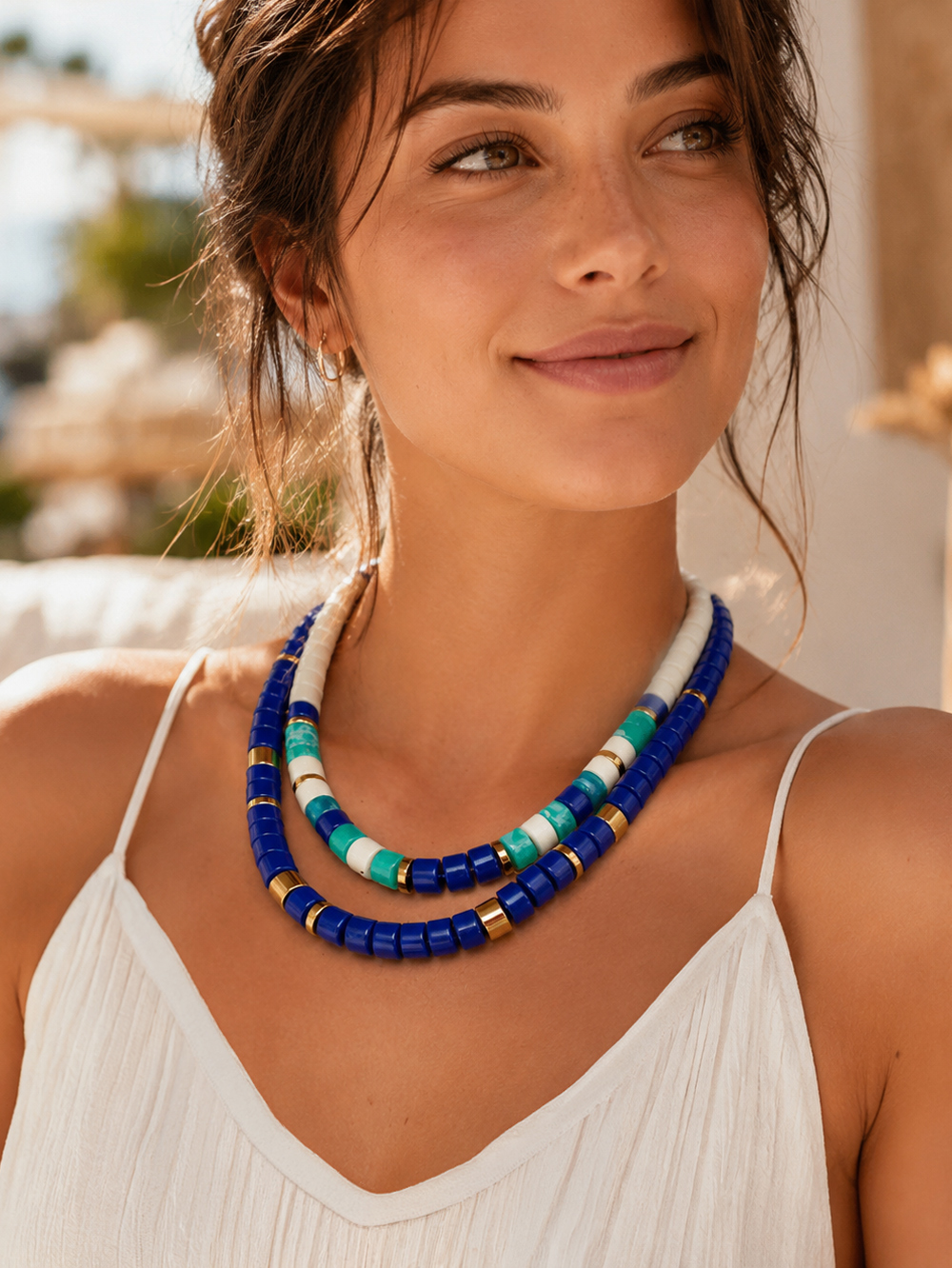 Collier Praia Azul Ivoire 2 Collier Praia Azul ivoire - modèle réglable en perles acryliques bleues et blanc ivoire. Il est porté par une femme avec le collier praia bleu cobalt.
